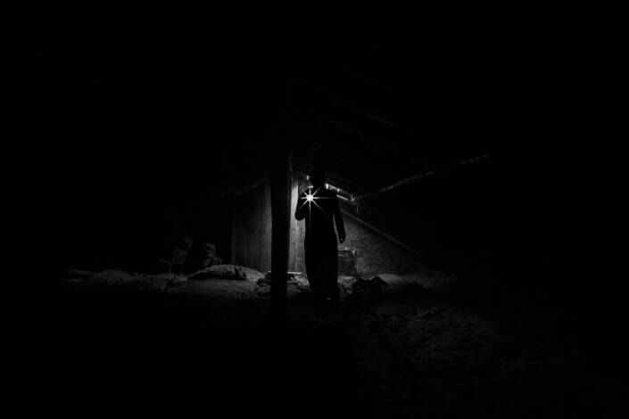 Man with a flashlight walking through the dark
