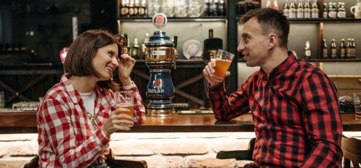 Man and woman talking to each other while having some beer