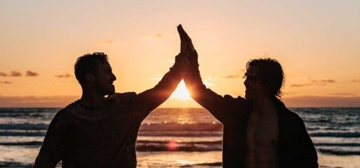 silhouette two men clapping each other 
