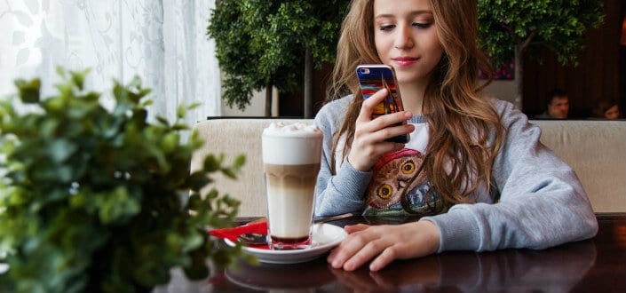 Girl capturing her coffee with her phone.