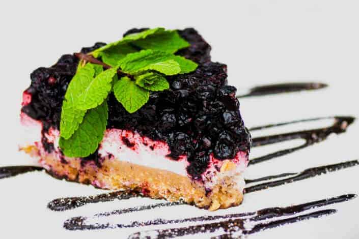 Blueberry cheesecake with mint on a plate.