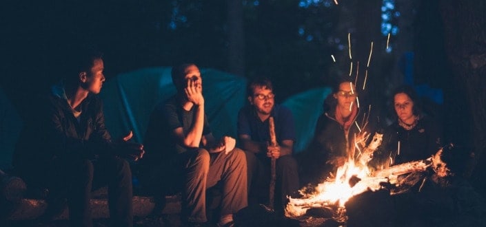 Group of friends camping with bonfire