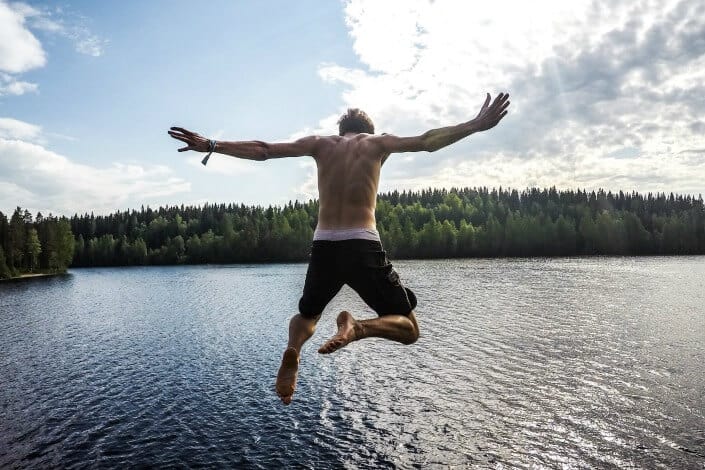 Guy jumping into a lake