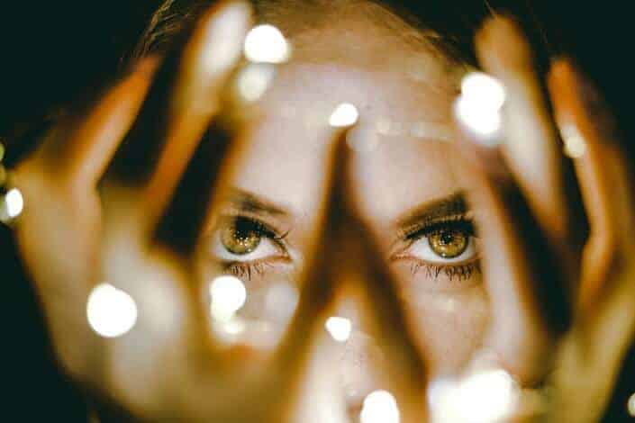 Girl covering her face with fairy lights