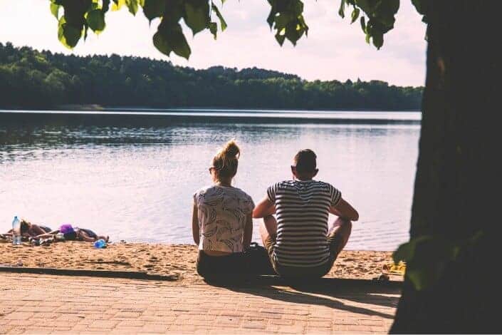 Couple sitting beside the lake