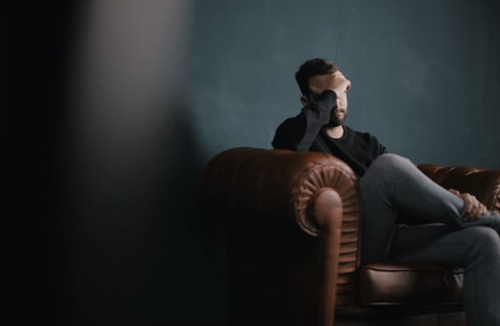 Man sitting on couch thinking deeply