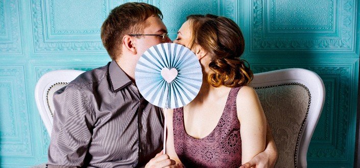 Woman and Man Sitting on Grey Suede Loveseat