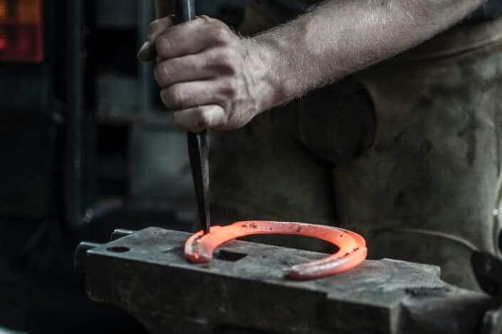 man forging horseshoe