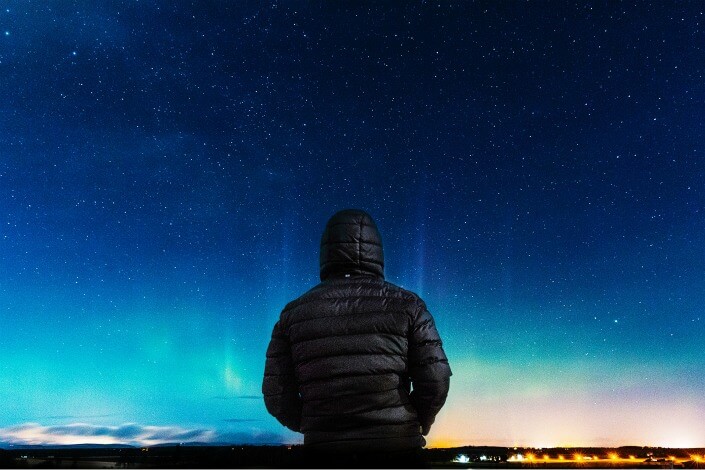 man in black hoodie looking at the stars