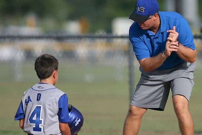 coach teaching the young kid about baseball