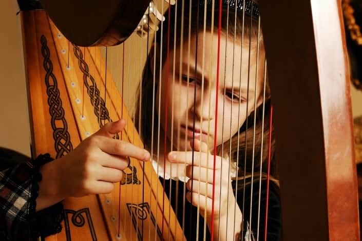 girl playing harp seriously