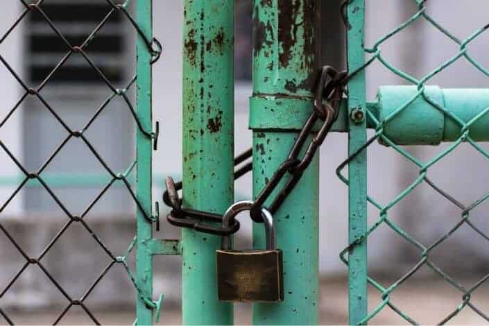 green metal gate with metal padlock