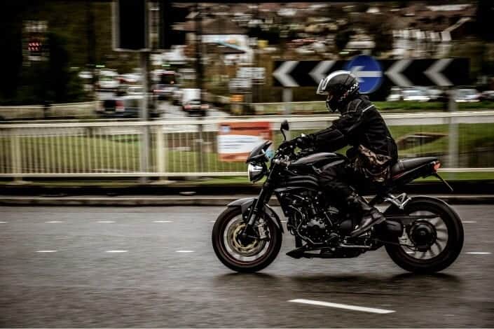 man in black riding his motorcycle