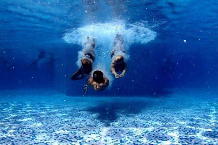 three person diving on water