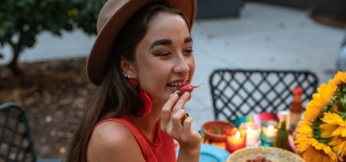 Girl about to eat a strange fruit.