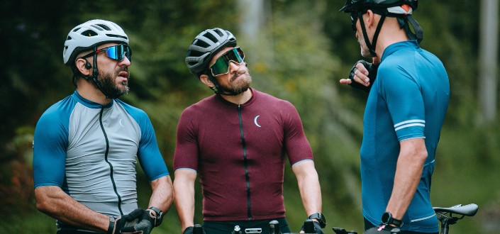 Three male bikers, talking while taking a rest.