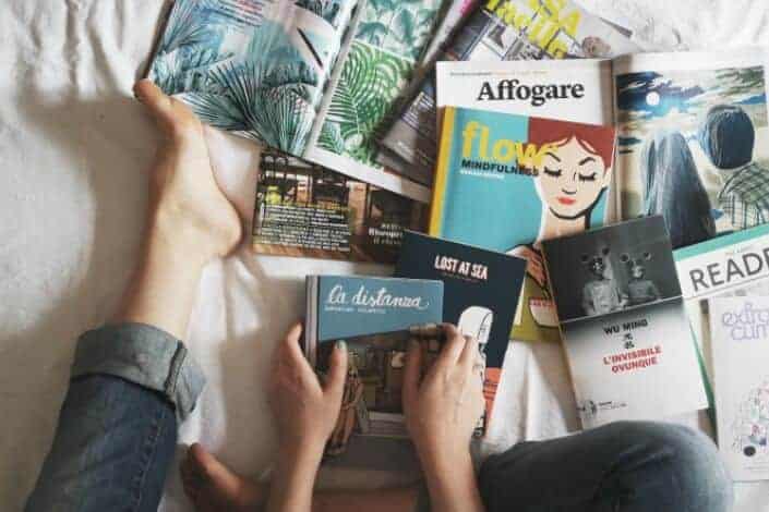 person holding blue book along with other books