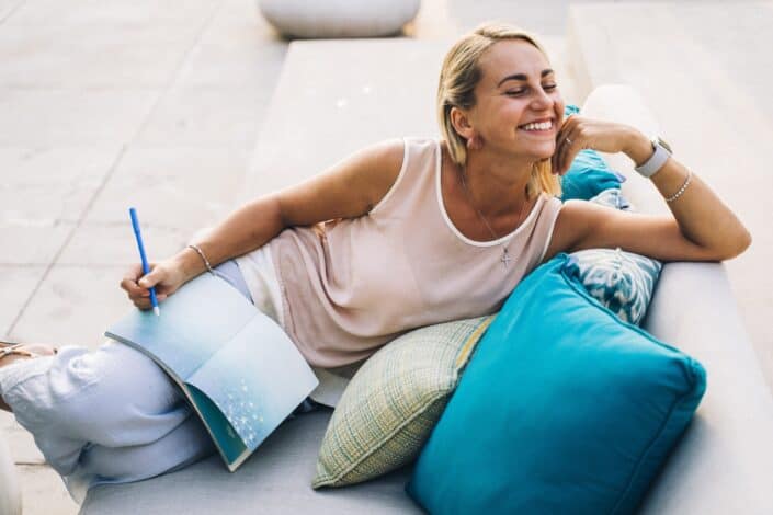 a-woman-in-a-tank-top-smiling-while-sitting-on-a-couch-