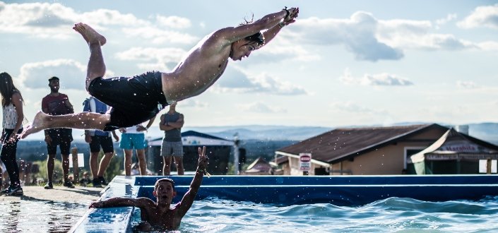 A guy doing an awkward dive in the pool