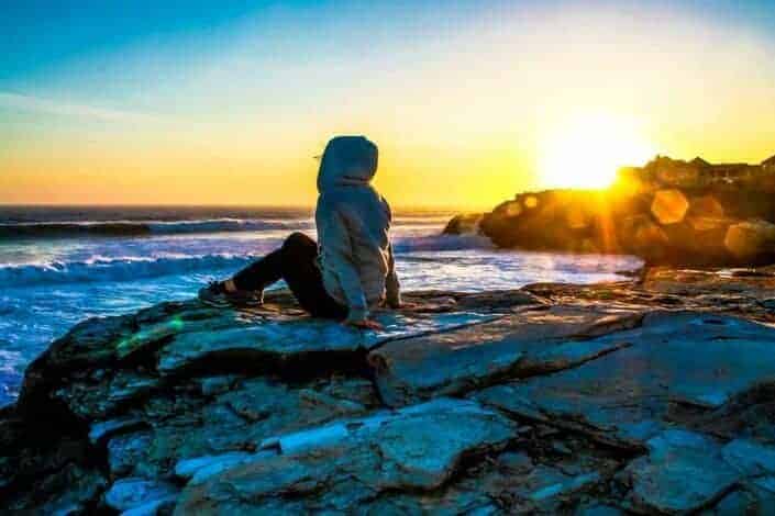 Woman sitting alone by the seashore