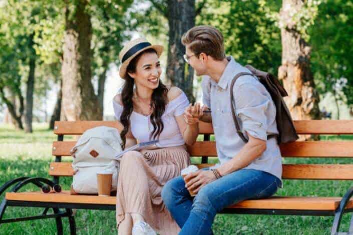 Couple sitting on bench while holding hands