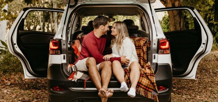 Couple sitting in car trunk
