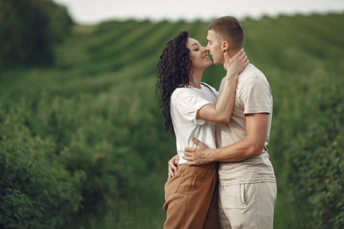 Couple standing on the field about to kiss 