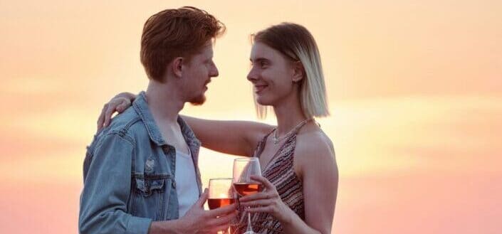Romantic couple holding glasses of wine 