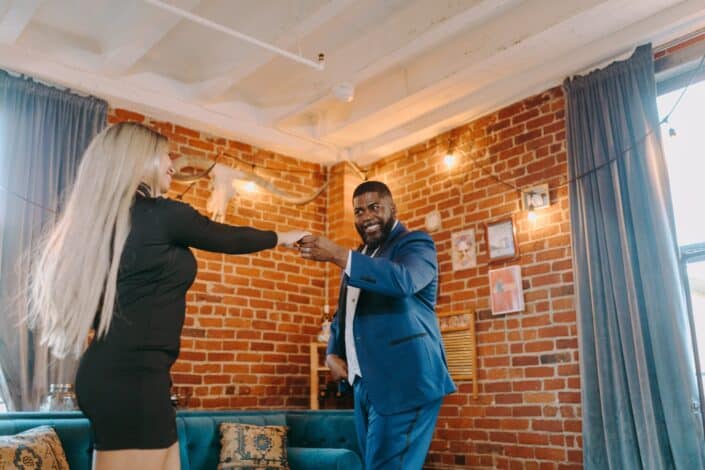 Couple dancing a happy dance while indoors