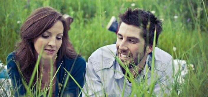 Man and woman talking while lying on the grass