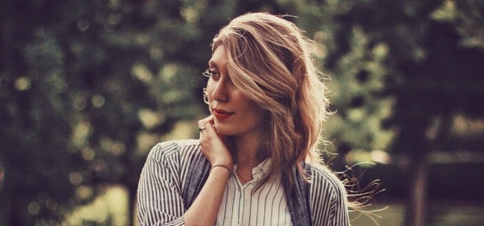 woman looking to her right while holding her hair