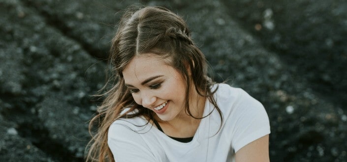 woman wearing white laughing while looking down