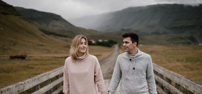 content-couple-strolling-along-wooden-path-in-remote-village-pexels