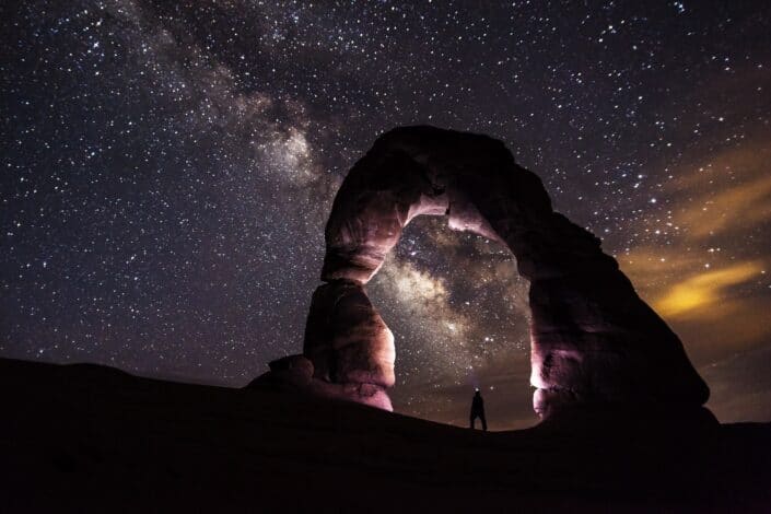 person-standing-under-a-rock-formation-on-a-starry-night-pexels