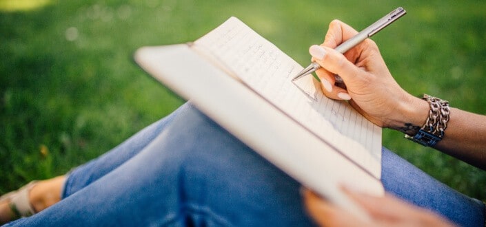 Woman writing notes on her lap