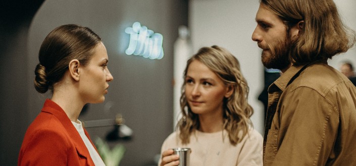 two people listening to a woman talk