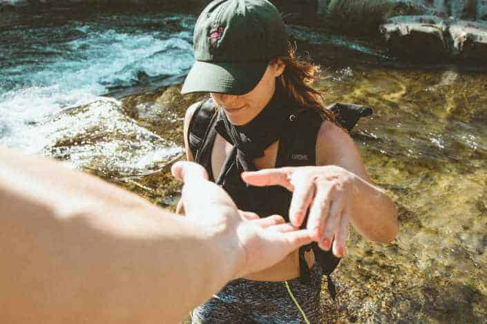 Guy reaching out hand to a girl on a hike