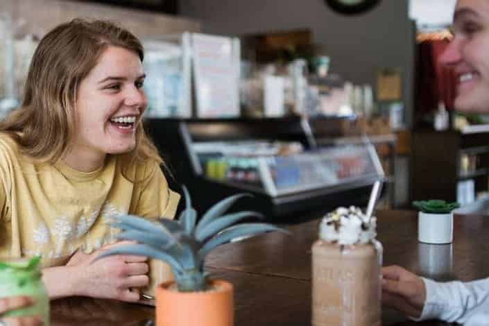 two friends laughing together in a cafe
