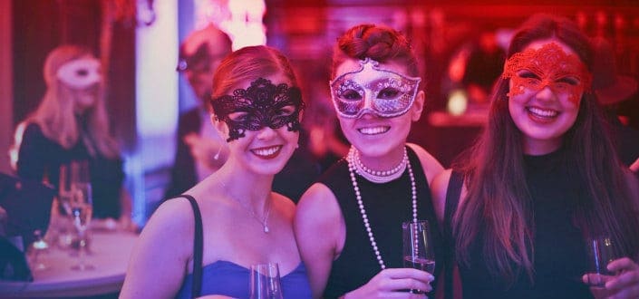 Women drinking at a mask party