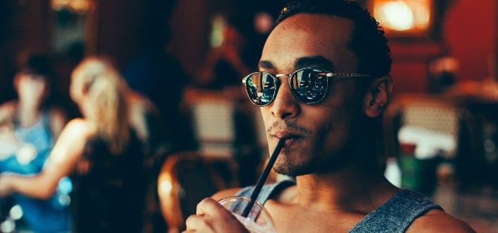 Man wearing eyeglass sipping on his drinks