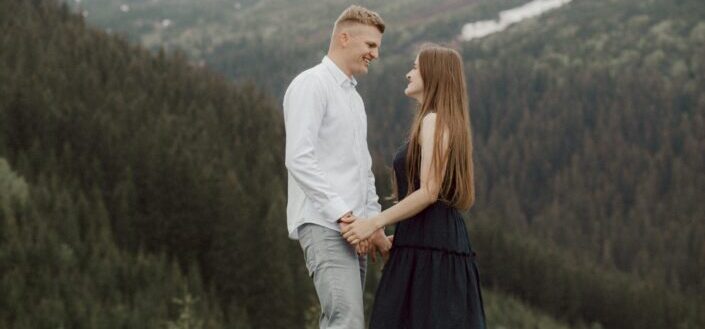 a sweet couple standing face to face while looking at each other 