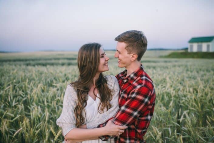 couple-hugging-and-looking-into-each-others-eyes-on-a-field-