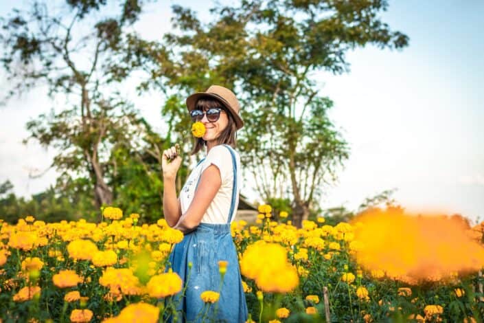 woman-sniffing-yellow-flowers-