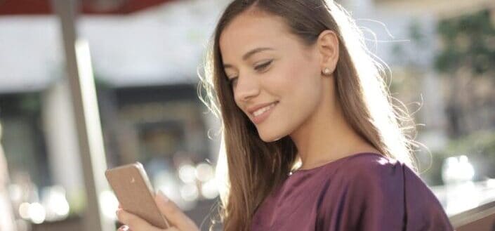 woman-in-purple-shirt-holding-iphone-