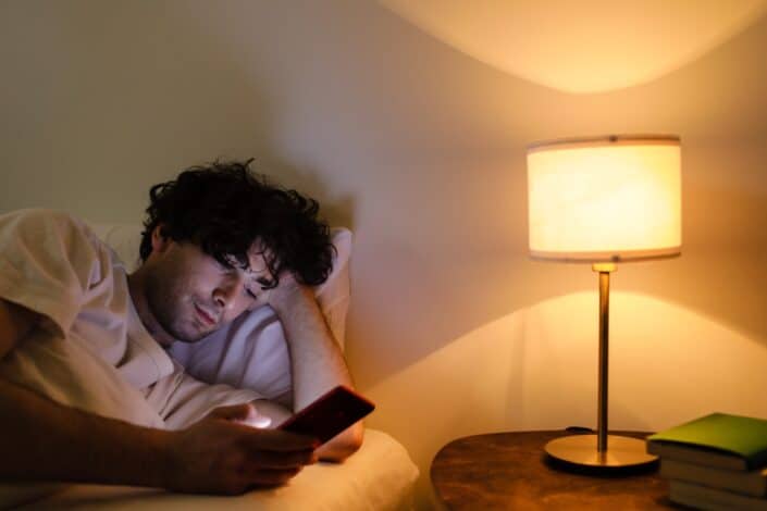 a-man-using-his-smartphone-while-in-bed-
