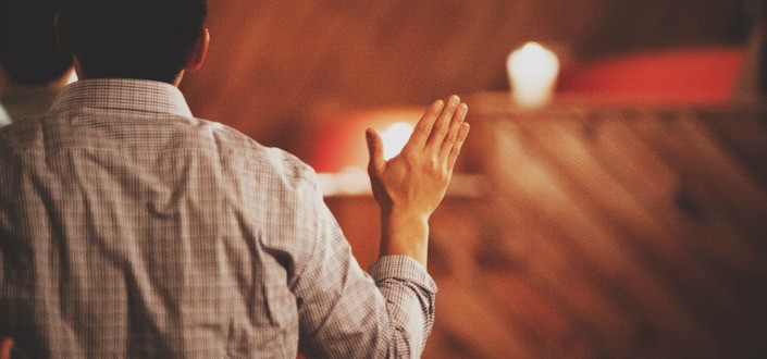 Man wearing checkered long sleeves raising his hands