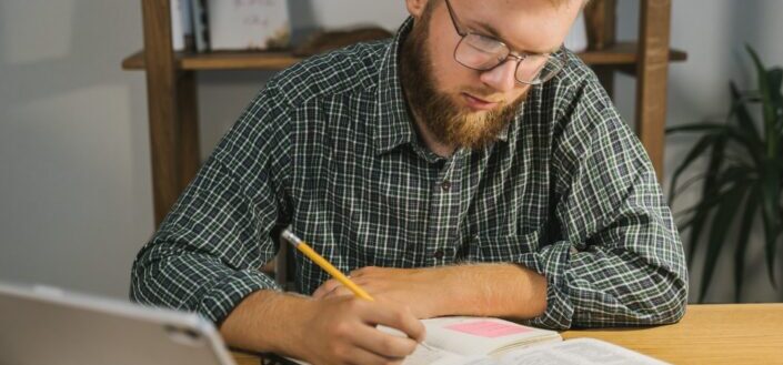 a-man-reading-bible-and-writing-on-notebook-