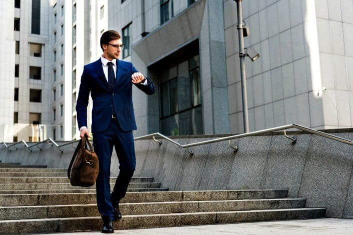 Man in blue suit checking time