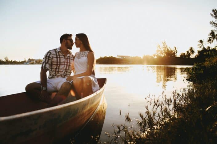 young-couple-spending-time-together-in-wooden-boat-floating-on-lake-