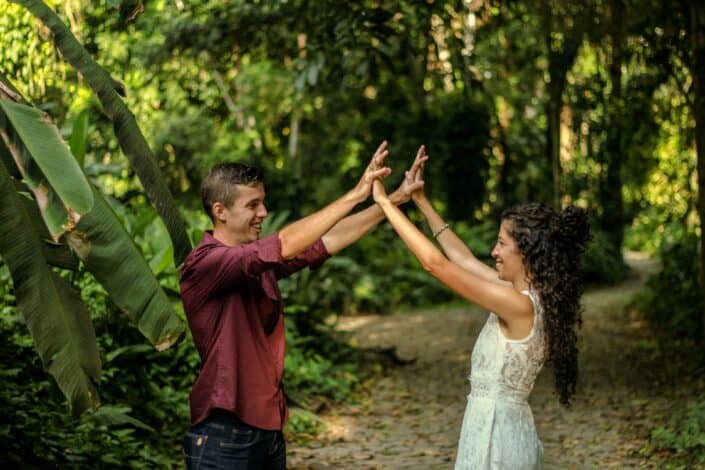 cheerful-couple-with-raised-arms-standing-in-jungle-